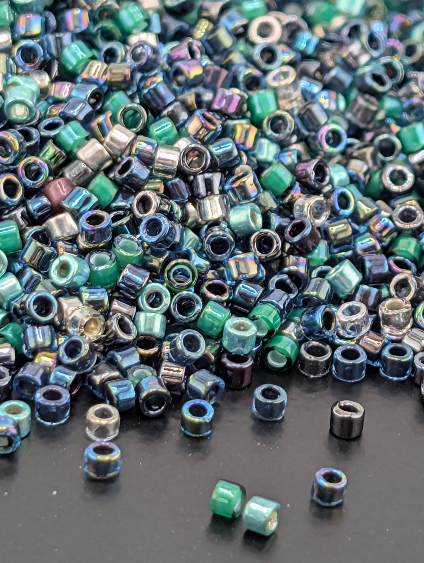 A pile of multicolored glass beads scattered on a dark surface.