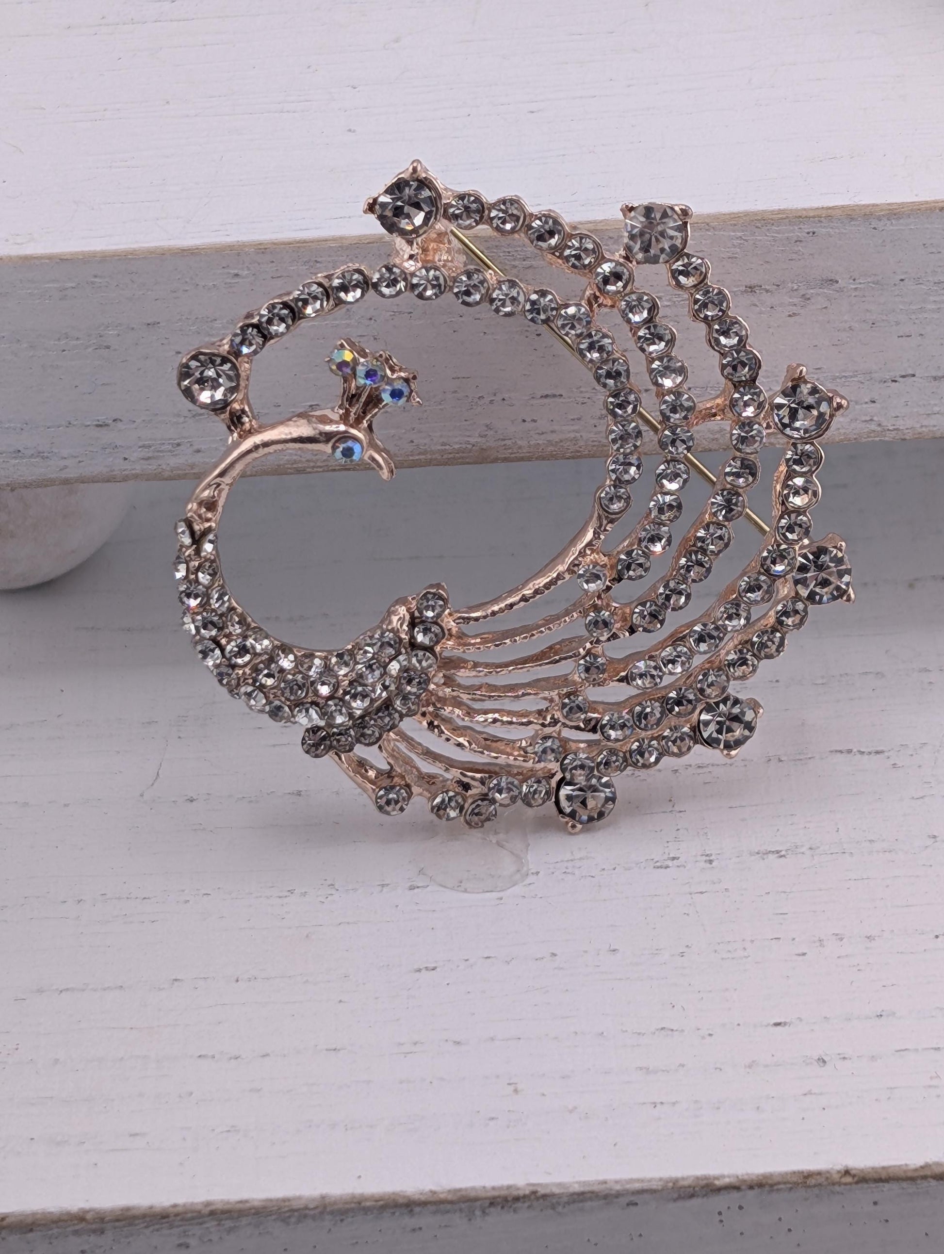 A decorative brooch with a peacock design, featuring a large, intricate piece of jewelry made of small, clear gemstones.