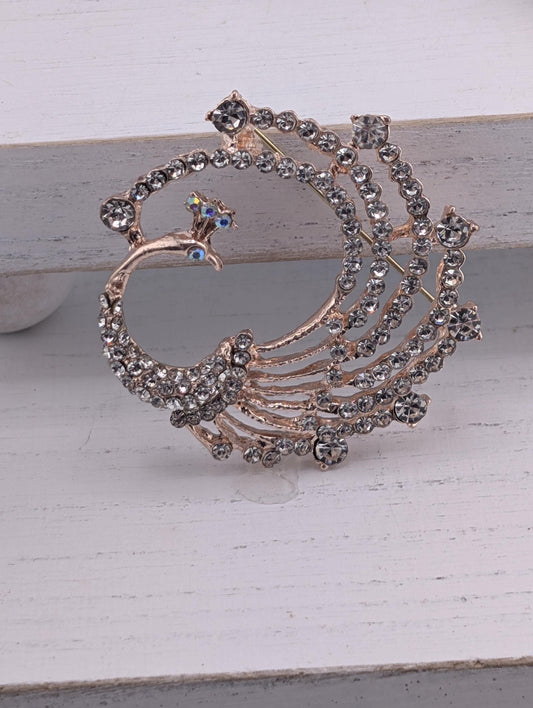 A decorative brooch with a peacock design, featuring a large, intricate piece of jewelry made of small, clear gemstones.