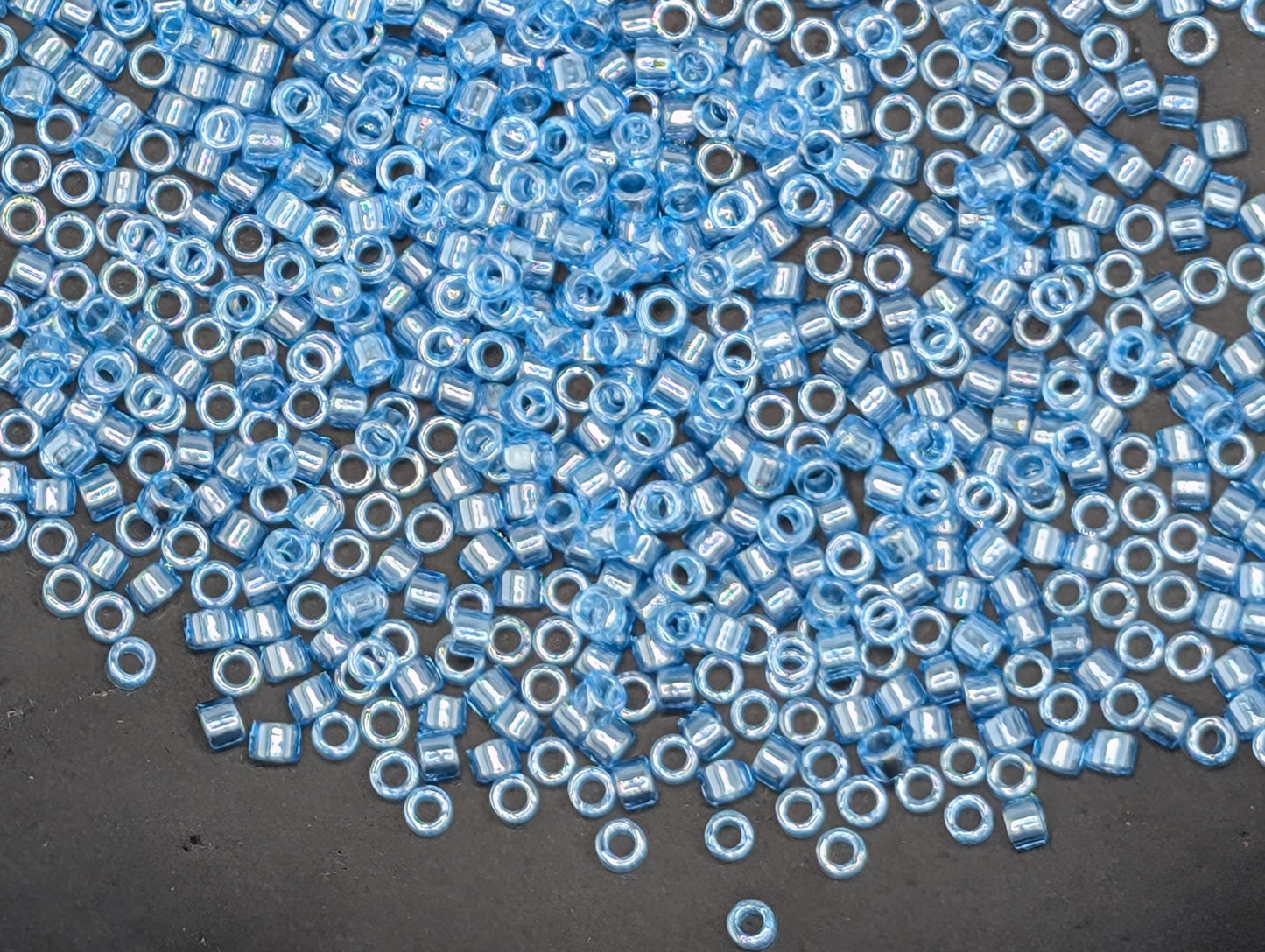 a large number of small, round blue beads scattered across a dark surface.