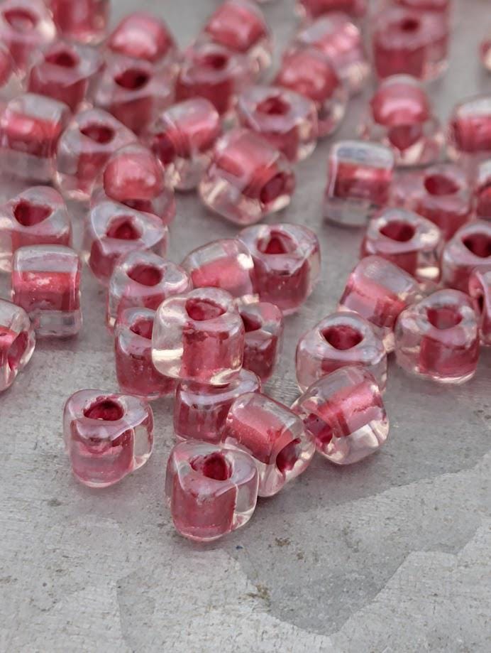 a collection of clear glass beads in various shapes and sizes, scattered on a surface.
