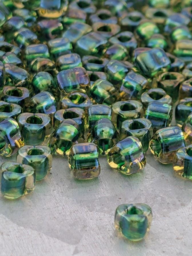 a close-up view of numerous green and yellow glass beads scattered on a surface.