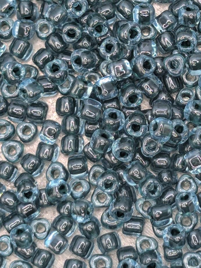 a close-up view of numerous small, clear beads in various shades of blue, scattered across a surface.