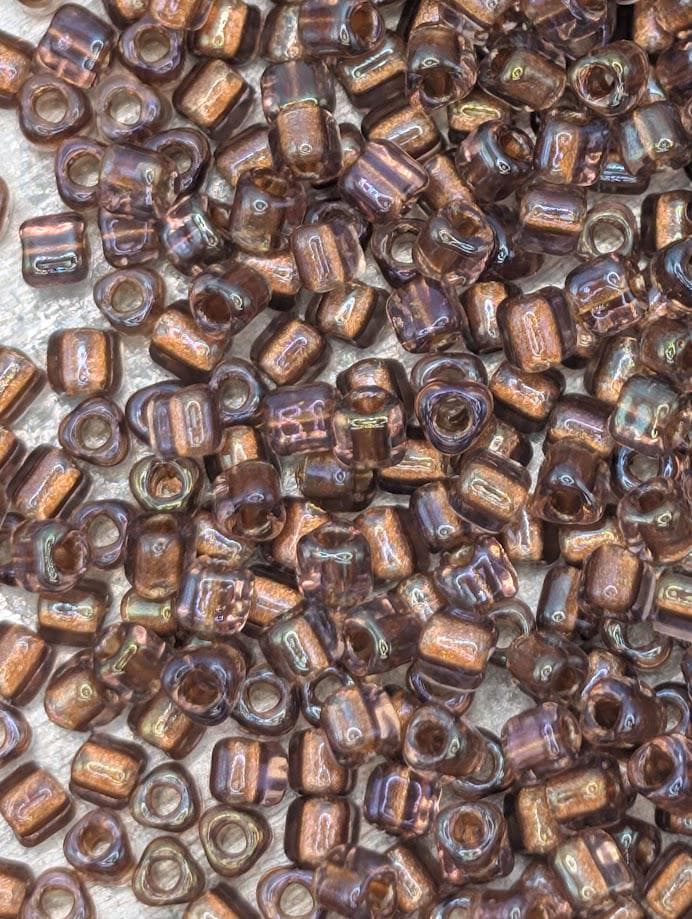 a close-up view of numerous small, brown glass beads scattered across a surface.