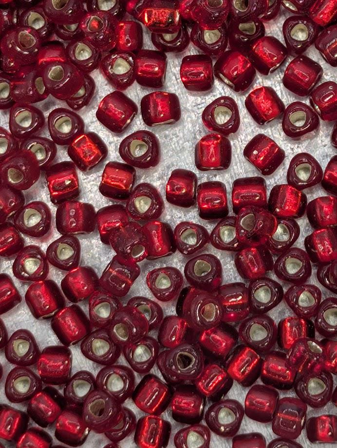 a close-up view of numerous red beads scattered across a surface.