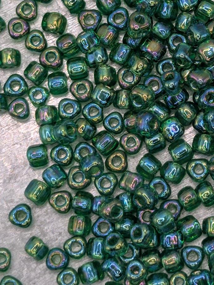 a close-up view of numerous green glass beads scattered across a surface.