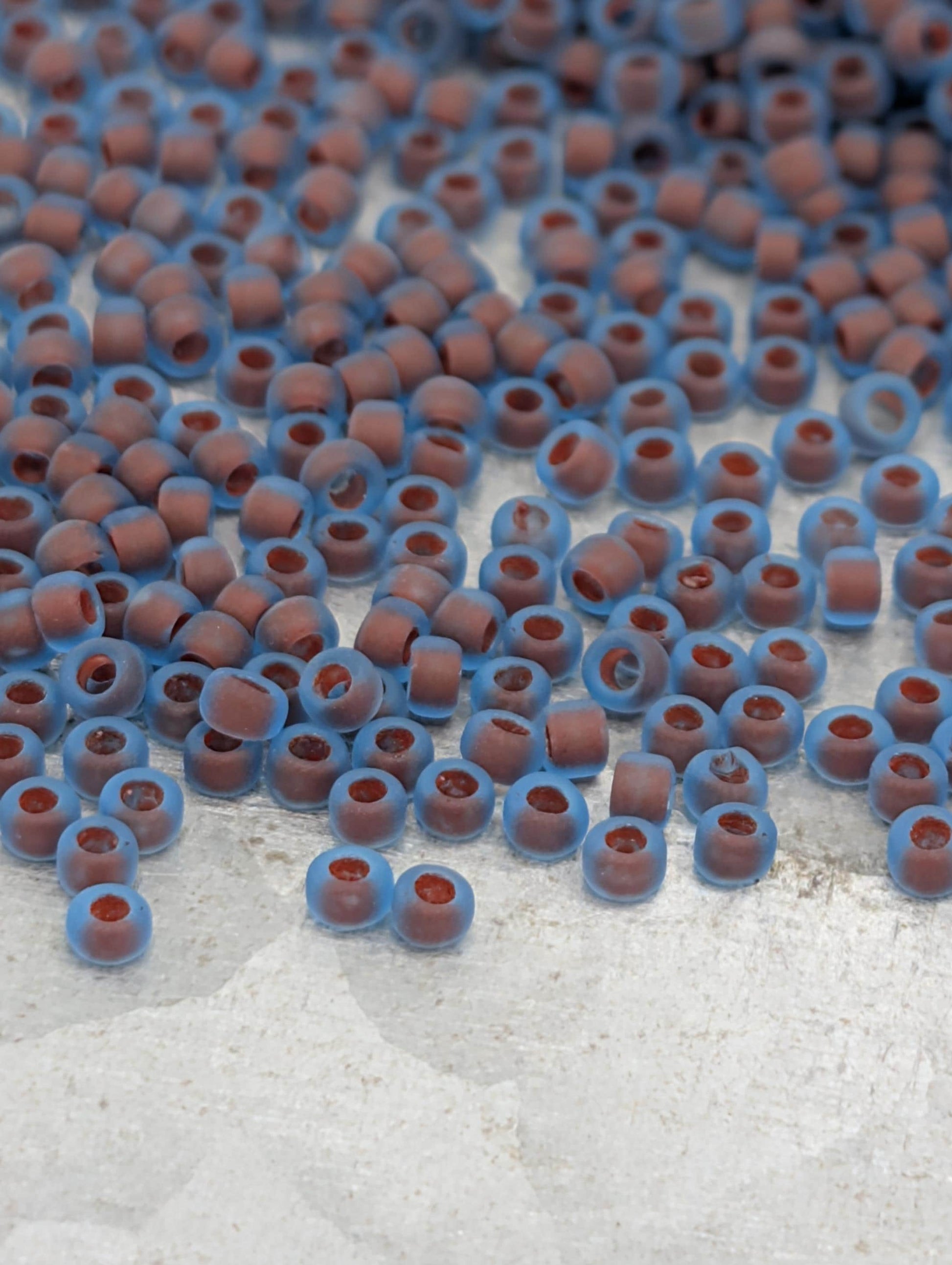 a collection of small, round beads in shades of blue and brown, scattered across a white surface.