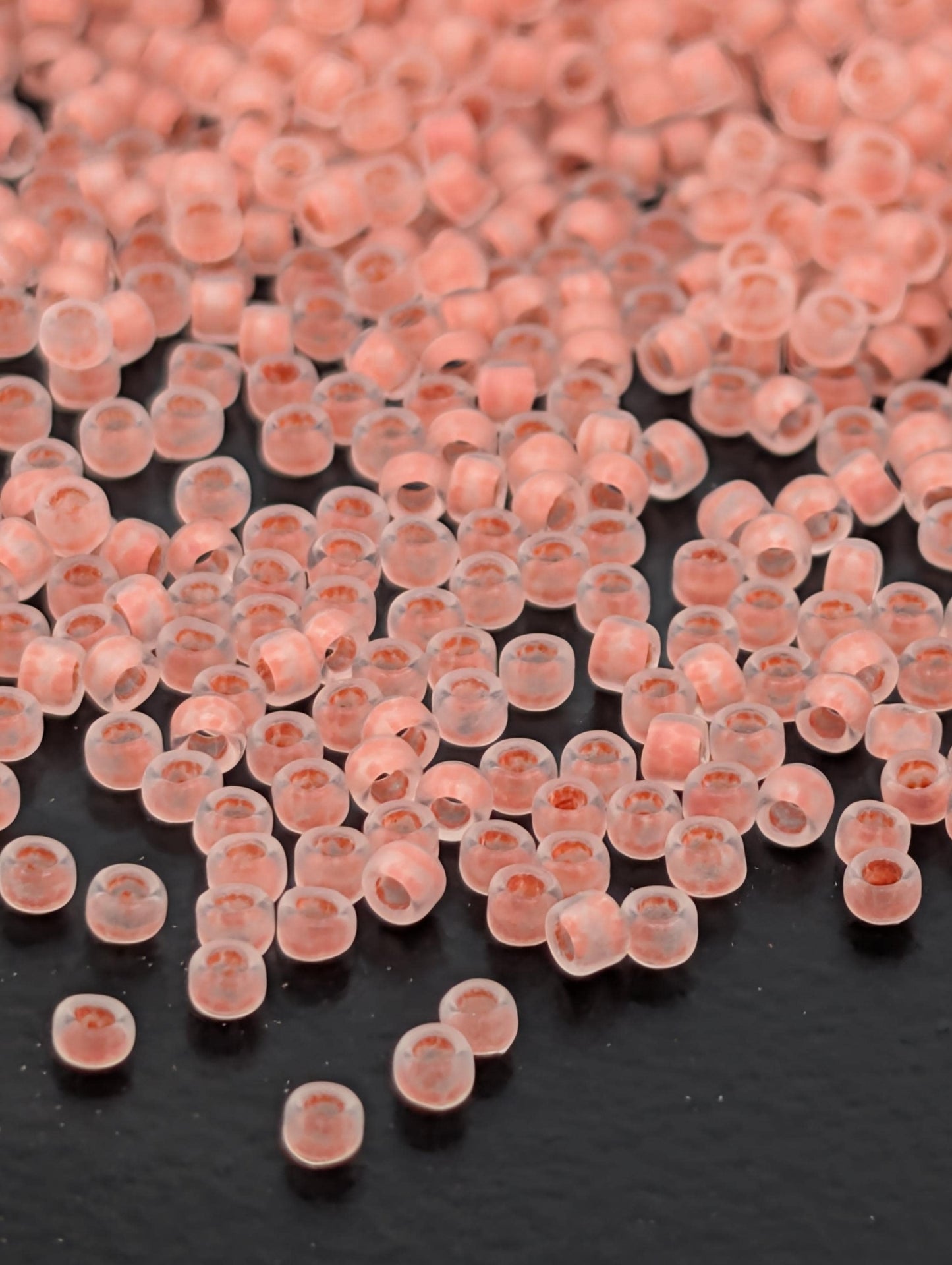 a close-up view of numerous small, clear beads scattered across a dark background.