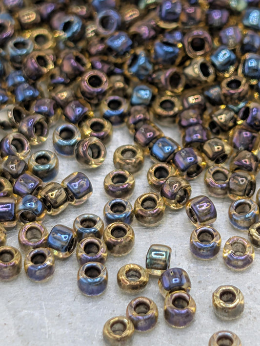 a collection of multicolored beads, including gold and blue, scattered across a surface.