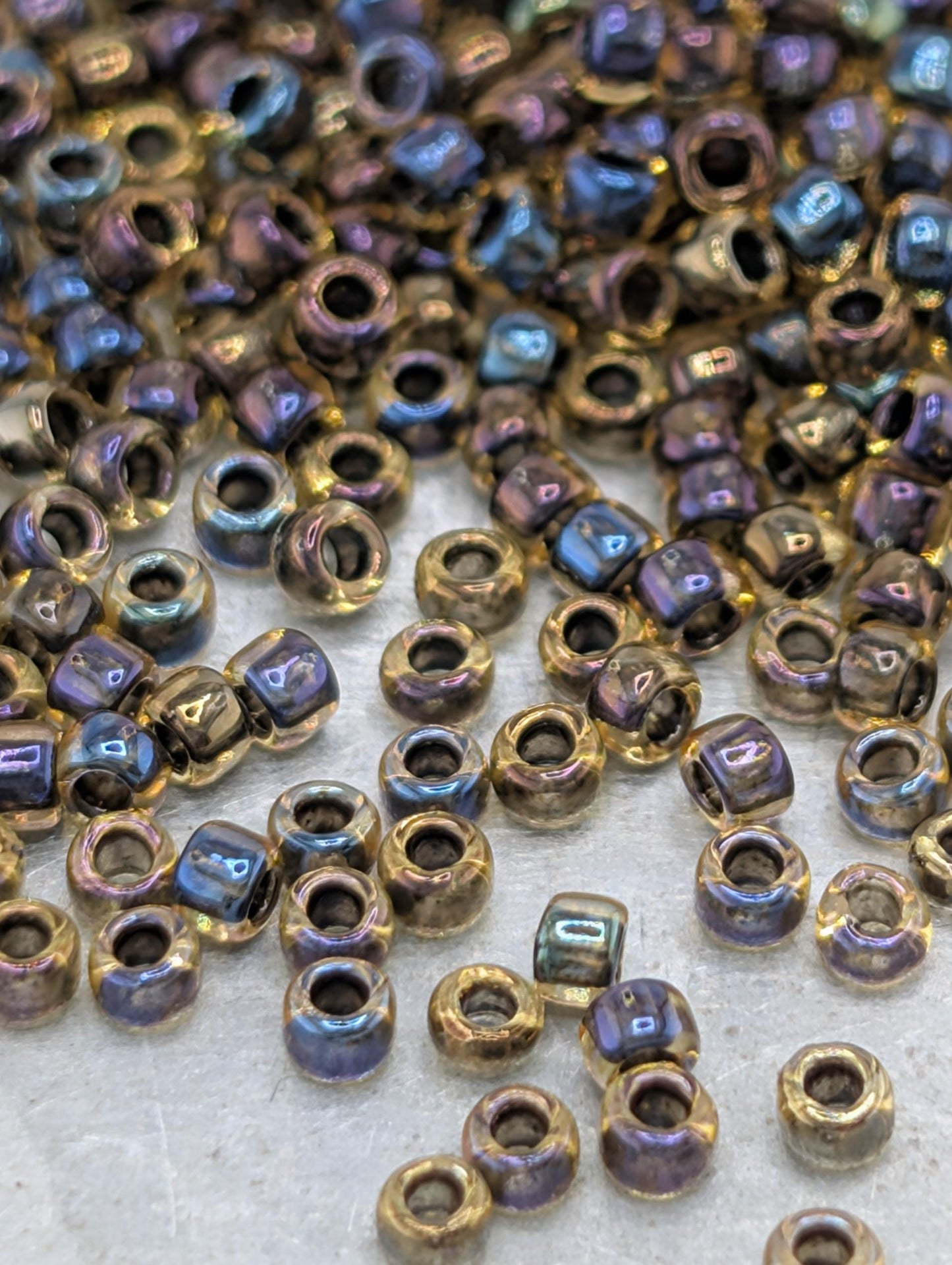 a collection of multicolored beads, including gold and blue, scattered across a surface.