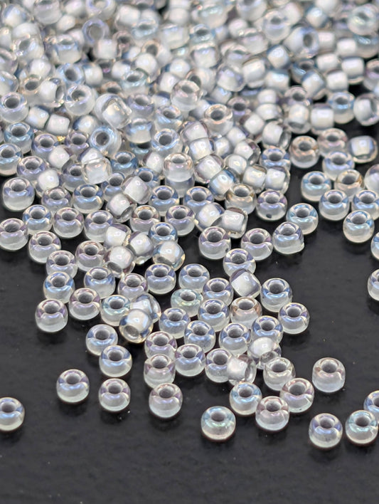 a collection of clear, transparent beads scattered on a dark surface.