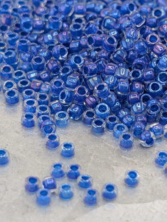 a large pile of blue and purple beads scattered on a surface, with some of the beads appearing to be broken or cracked.