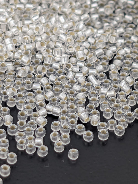 a close-up view of numerous clear beads scattered across a dark background.
