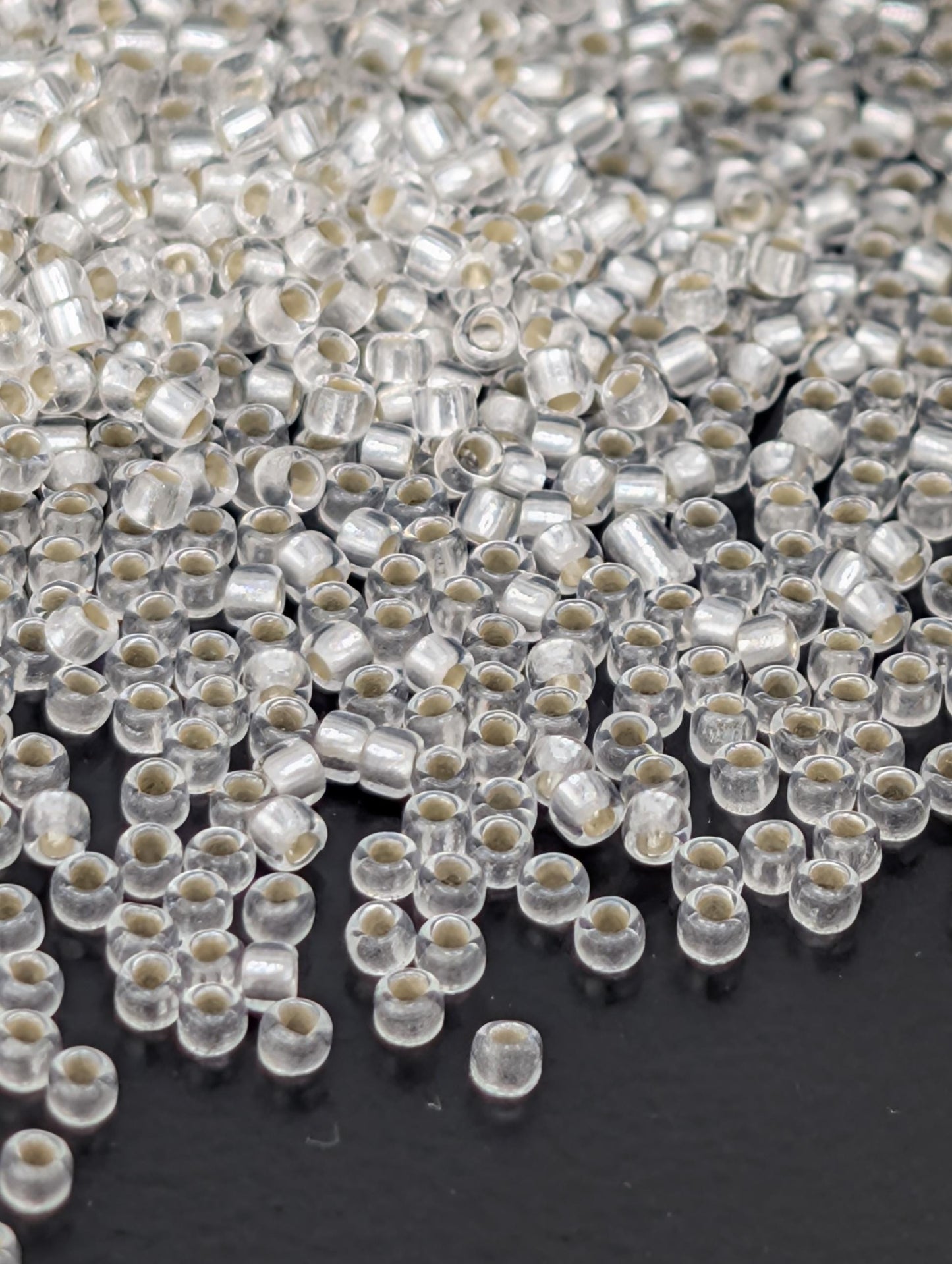 a close-up view of numerous clear beads scattered across a dark background.