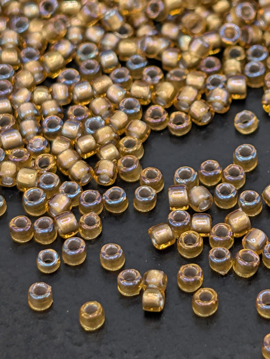 a collection of small, clear beads scattered on a dark surface.