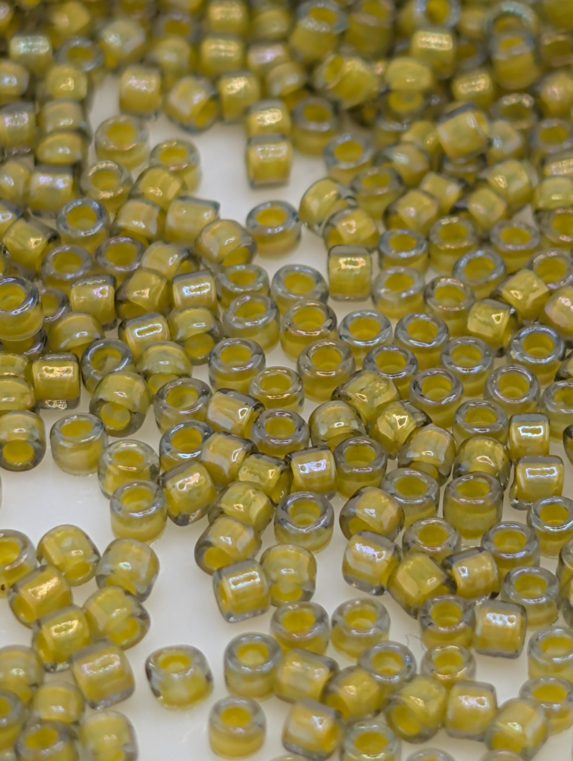 numerous small, yellow glass beads scattered across a surface.