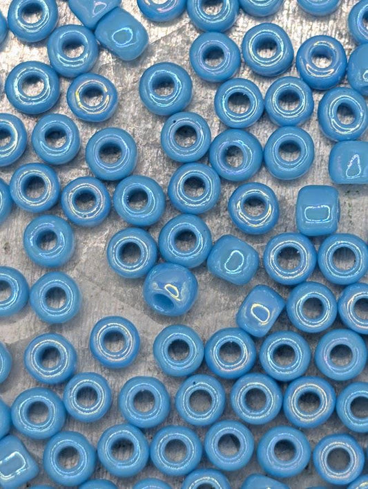 a collection of blue beads scattered across a surface, with some of the beads overlapping each other.