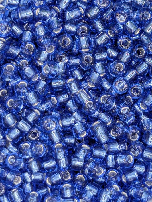 The image is a close-up of numerous blue glass beads or beads, arranged in a visually appealing manner.
