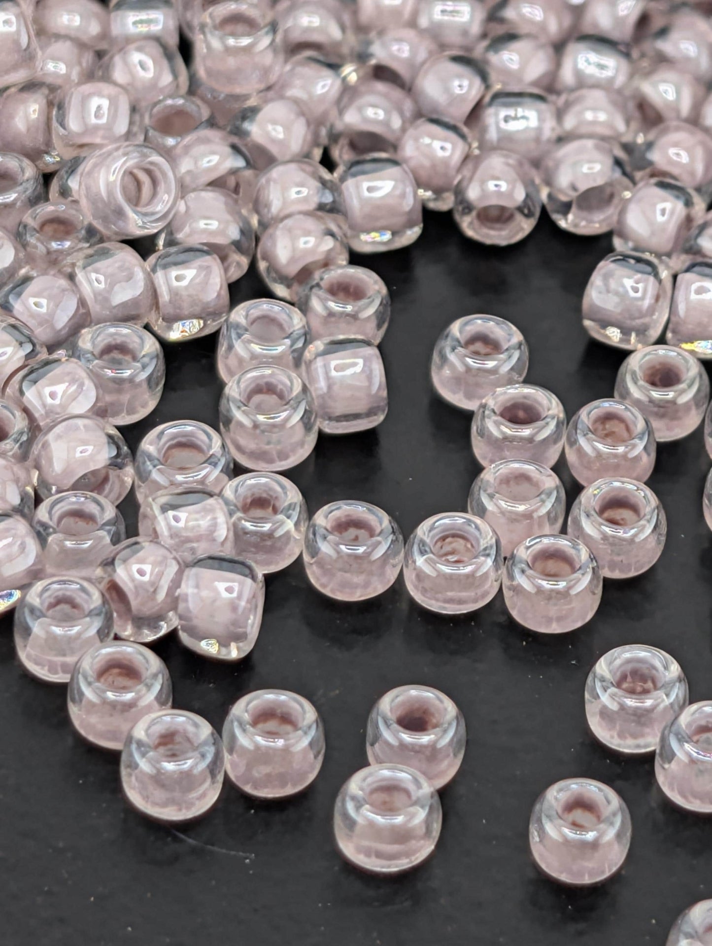 a collection of clear glass beads scattered on a dark surface.