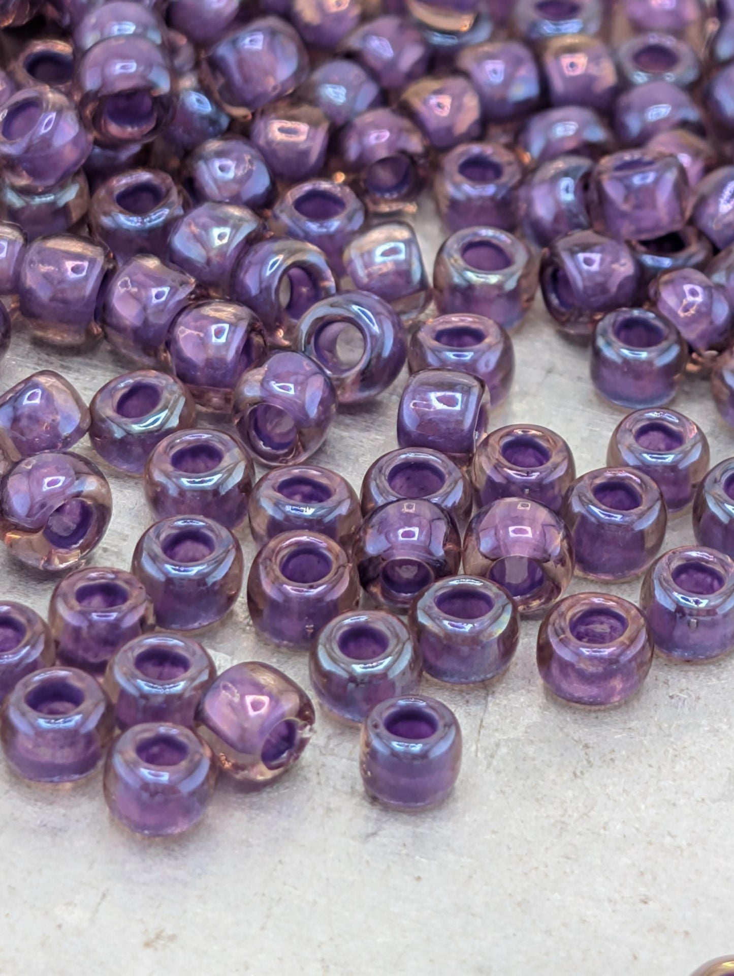 a collection of small, round beads in various shades of purple, scattered across a surface.