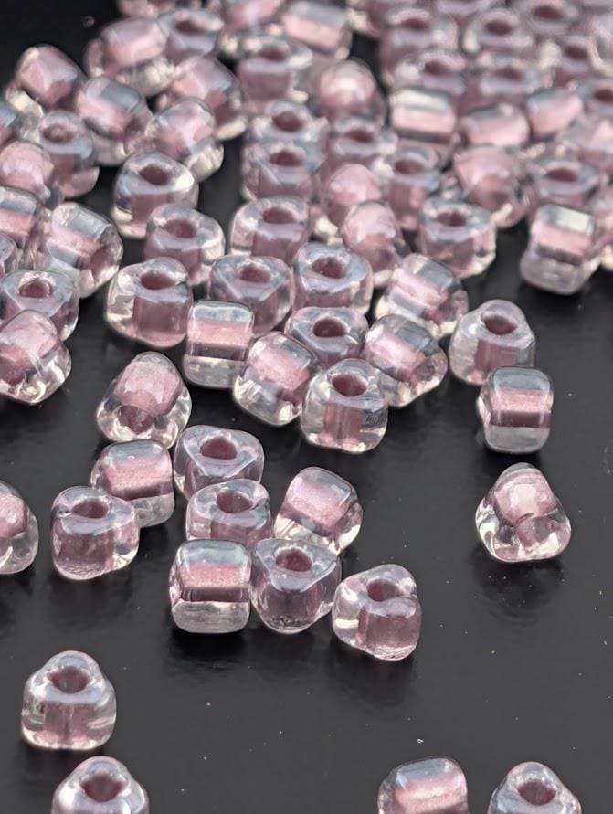 a collection of clear glass beads scattered on a dark surface.