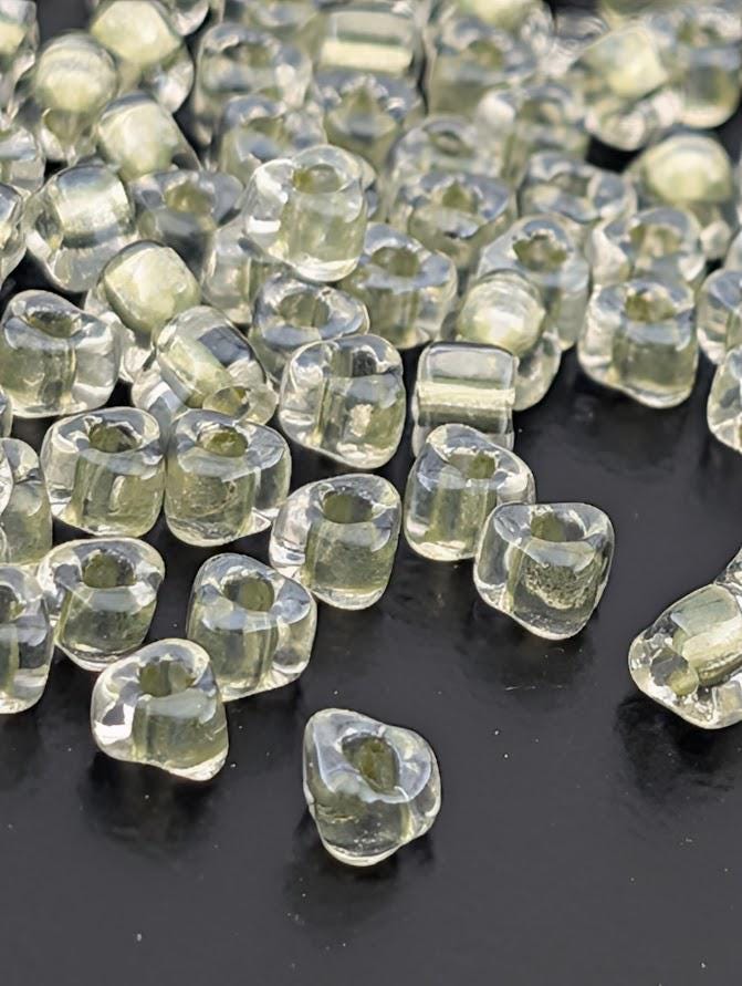 a collection of clear, transparent beads scattered on a dark surface.