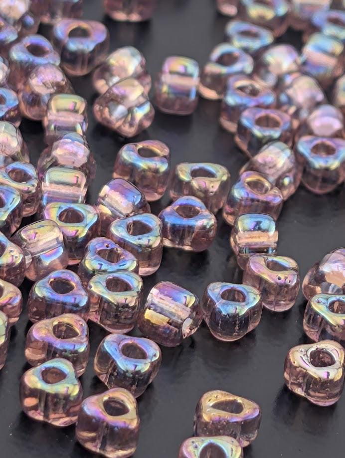 a collection of small, clear beads scattered on a dark surface.