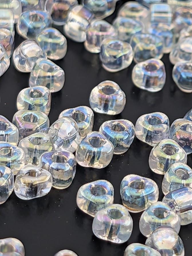 a collection of clear, transparent beads scattered across a dark background.