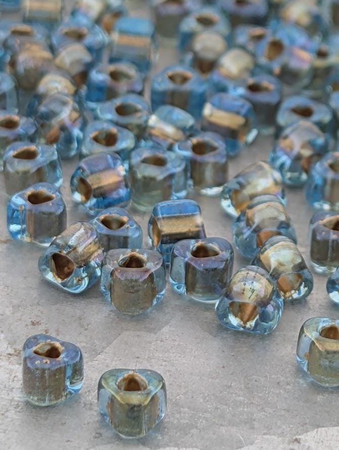 a collection of small, clear glass beads scattered on a surface.