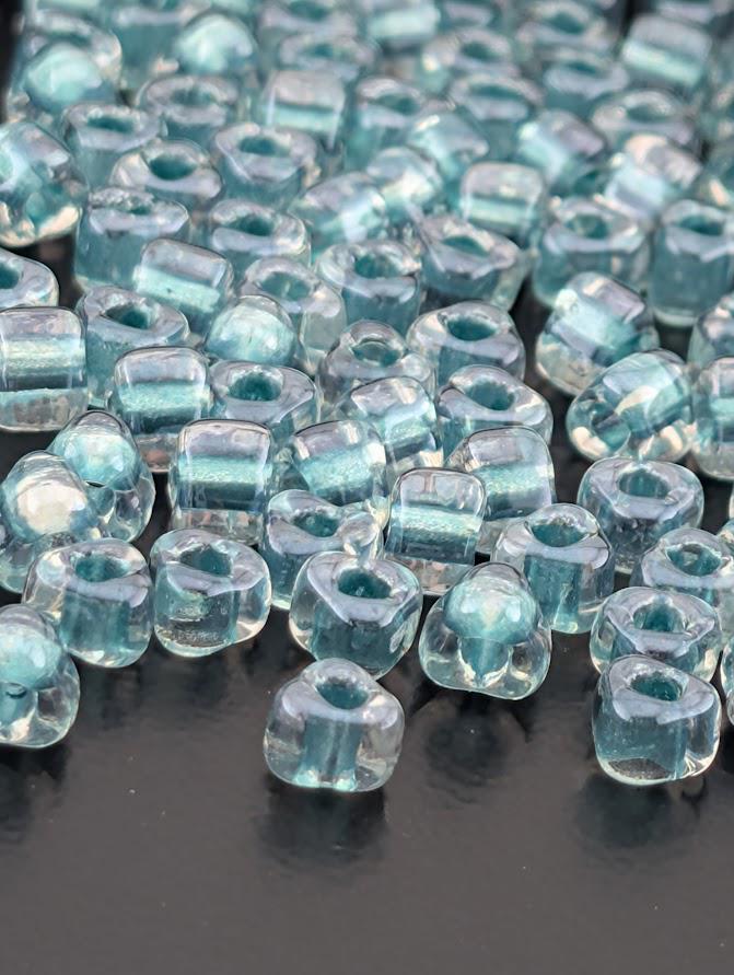 a collection of clear glass beads scattered across a dark surface.