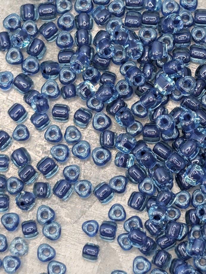 a collection of small, clear beads in various shades of blue, scattered across a surface.