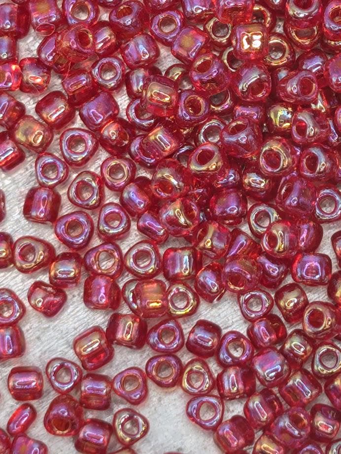 a close-up view of numerous red glass beads scattered across a surface.