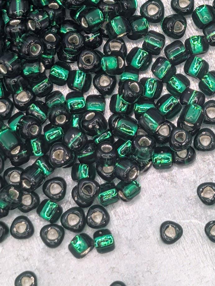 a collection of green and black beads scattered on a surface.