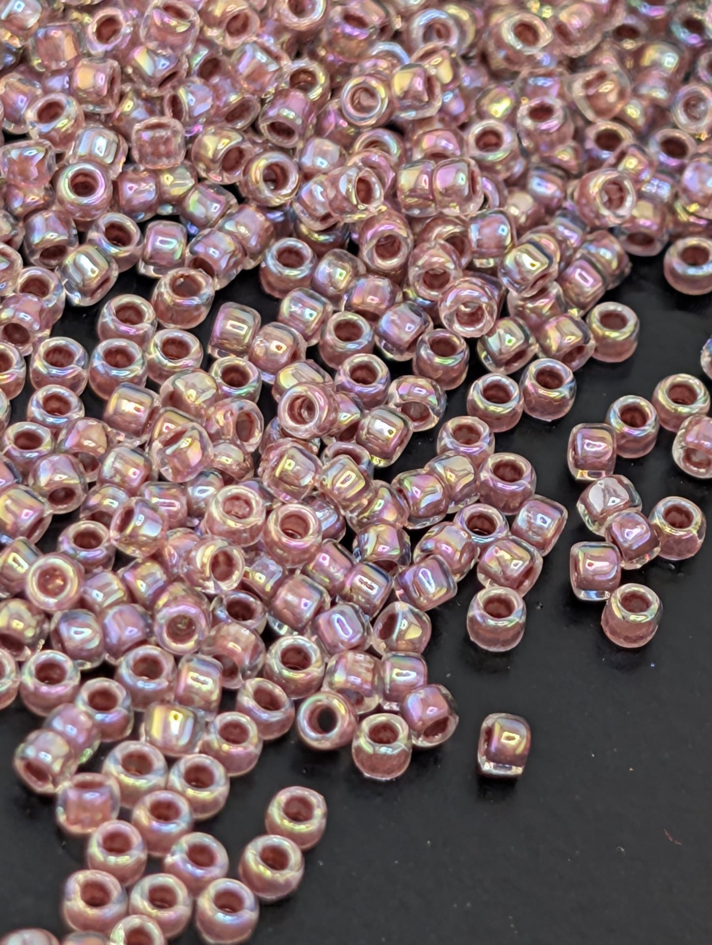 a close-up view of numerous small, round beads scattered on a dark surface.
