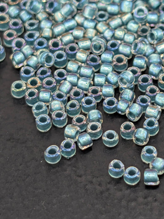 a collection of small, clear beads scattered on a dark surface.