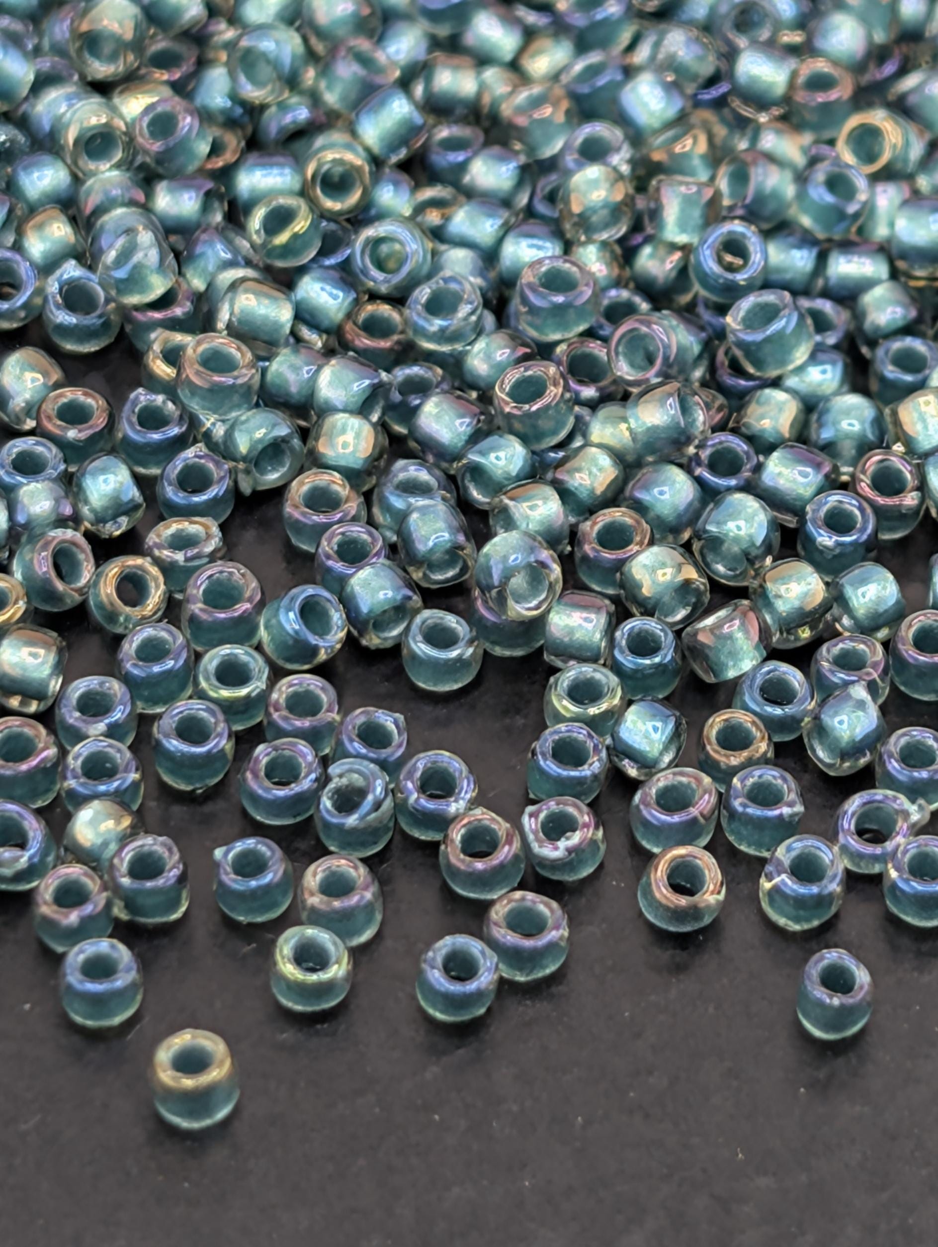 a collection of small, colorful beads scattered on a dark surface.