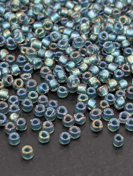 a collection of small, colorful beads scattered on a dark surface.