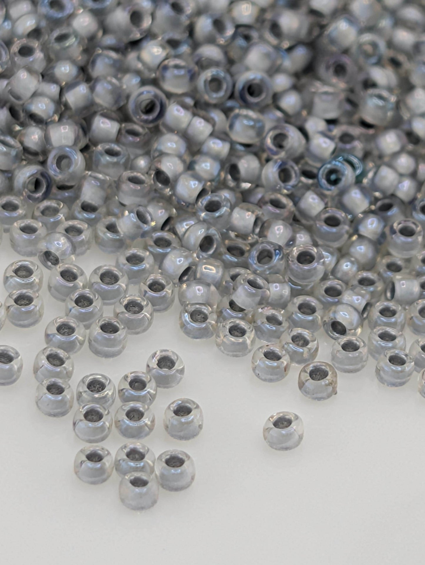 a large pile of clear, shiny beads scattered across a white surface.