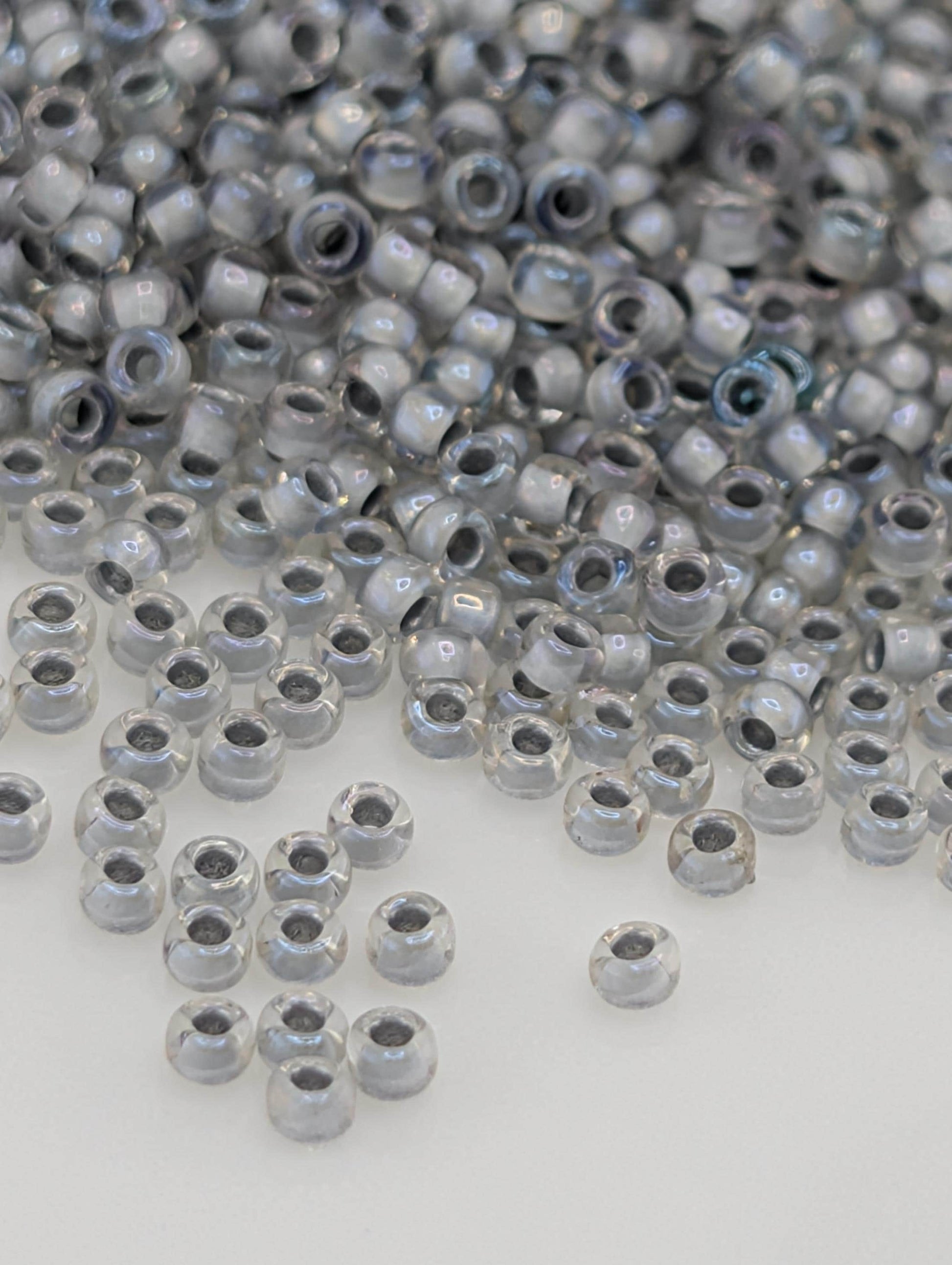a large pile of clear, shiny beads scattered across a white surface.