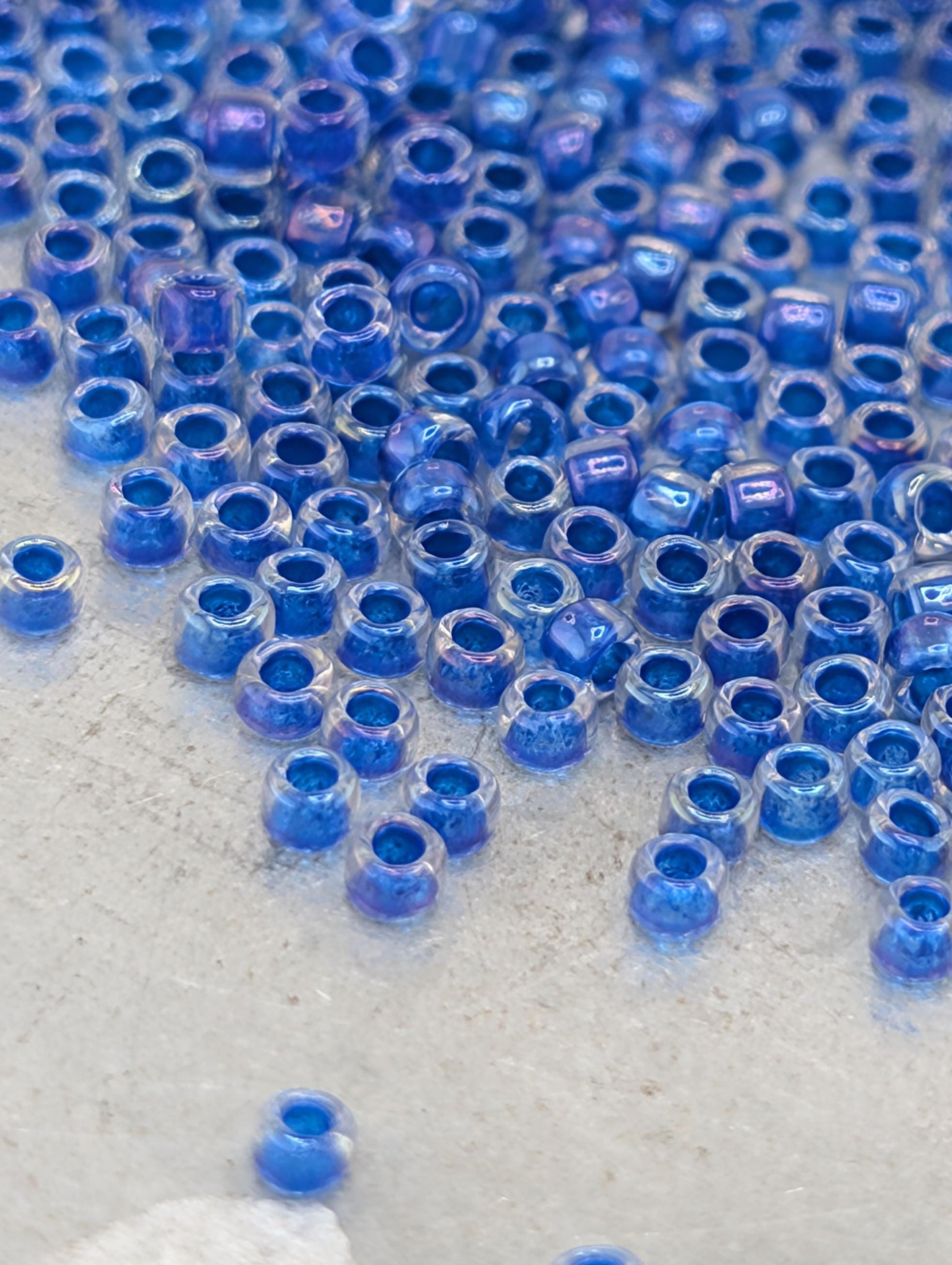 a close-up view of numerous blue and clear beads scattered across a surface.