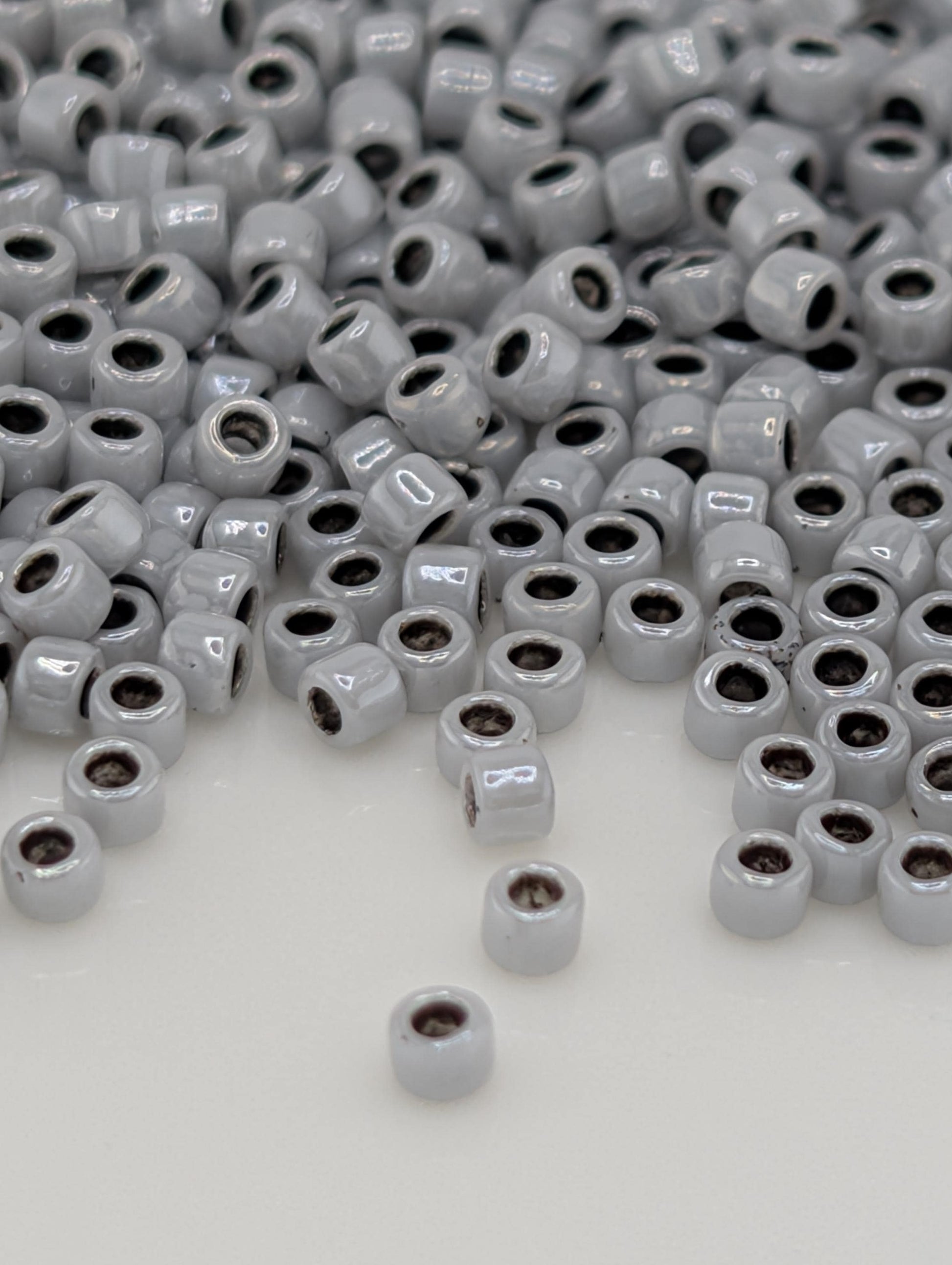 a large pile of small, white beads scattered across a white surface.