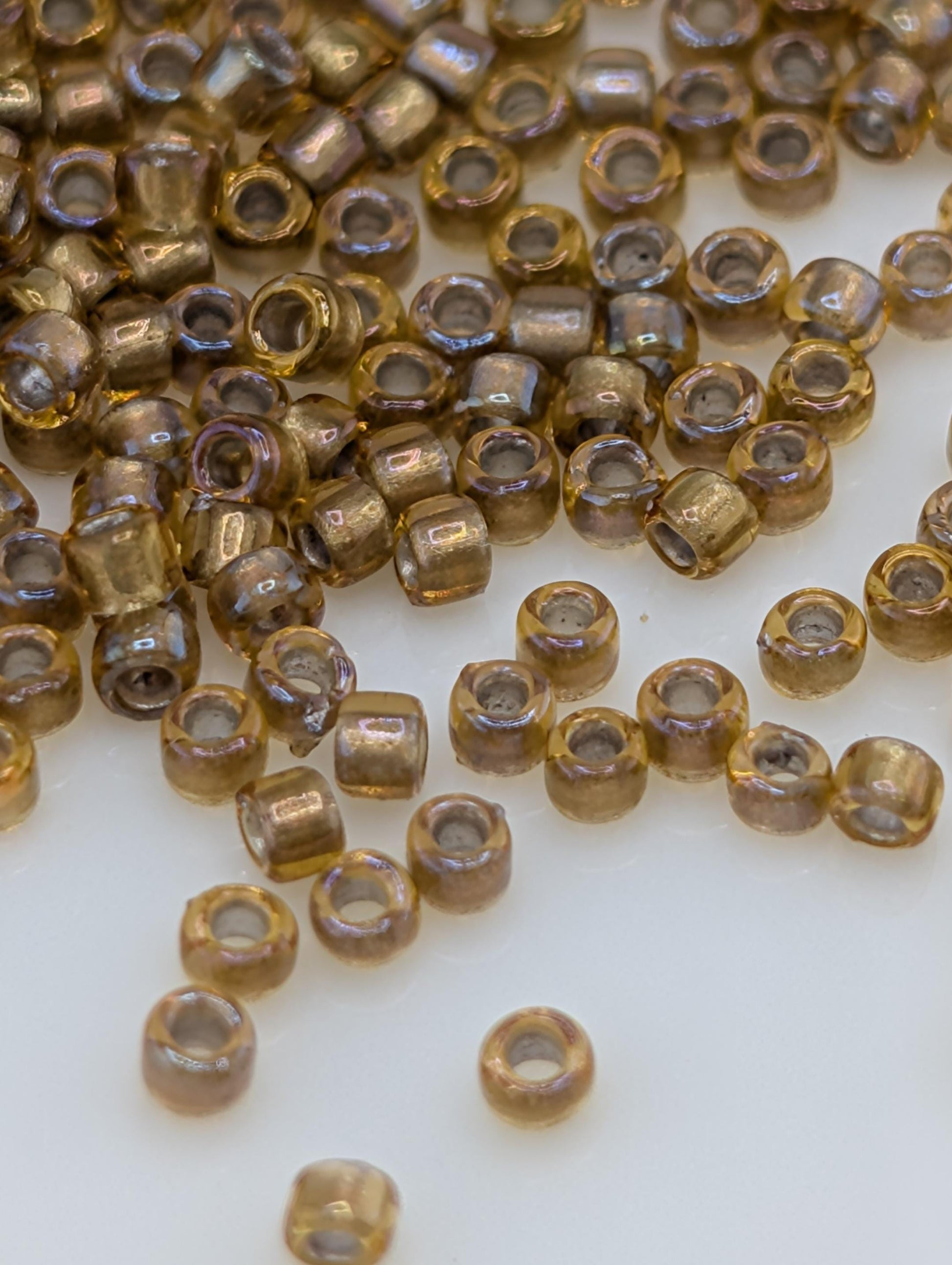 a collection of small, round, and shiny beads scattered on a white surface.