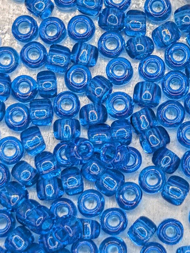 numerous blue glass beads scattered across a surface.