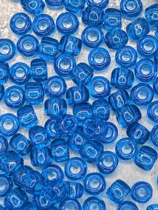 numerous blue glass beads scattered across a surface.