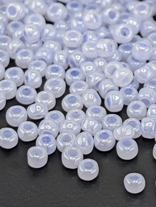 a collection of small, white beads scattered on a dark surface.