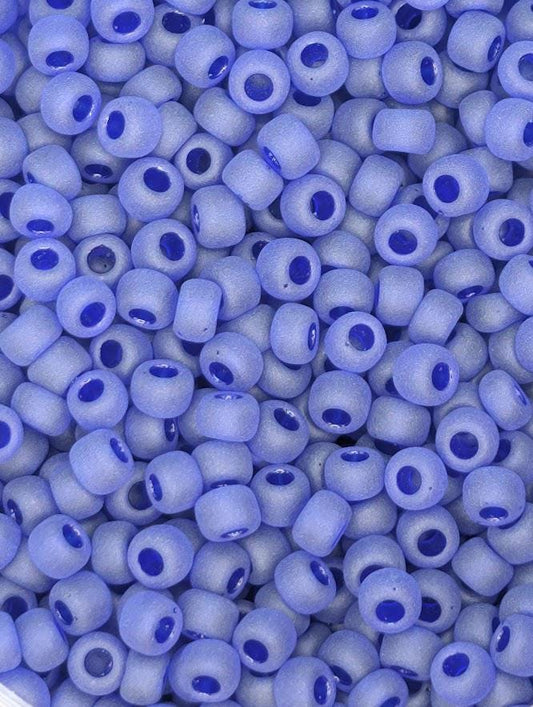 a close-up view of numerous small, round beads in a light blue color, with some of them having small blue accents.