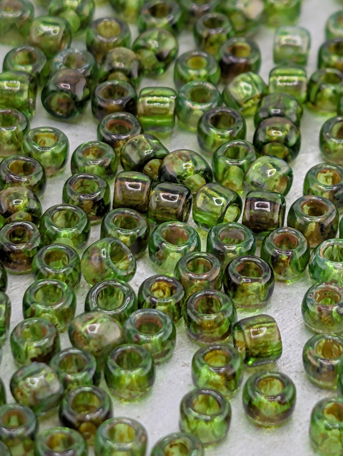 a collection of green glass beads scattered across a surface.