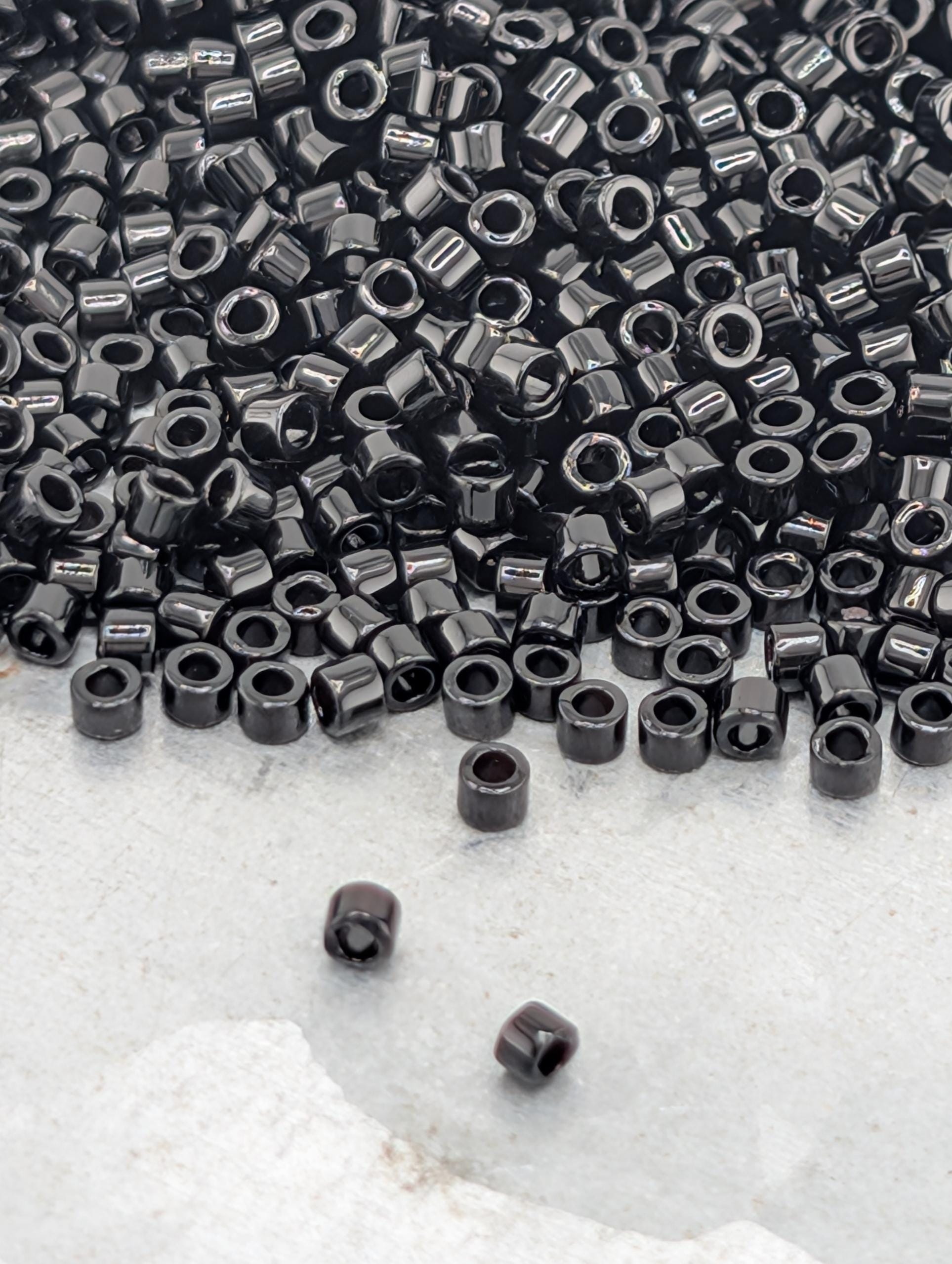 a large pile of black beads or nuts scattered on a white surface.
