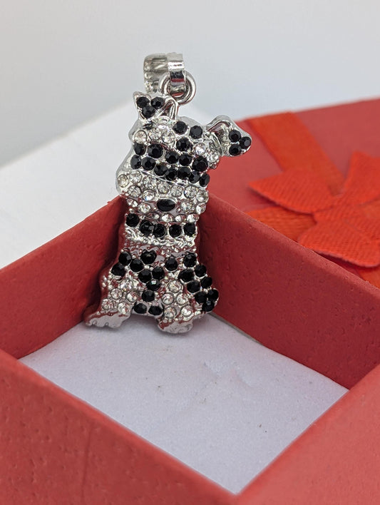 A silver charm in the shape of a dog is displayed in a red box.