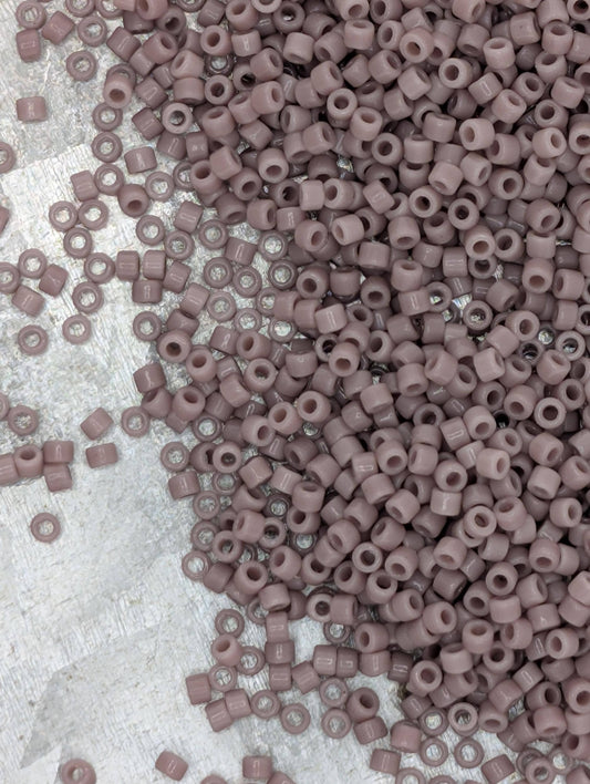 a large pile of small, round beads in various shades of pink, scattered across a surface.